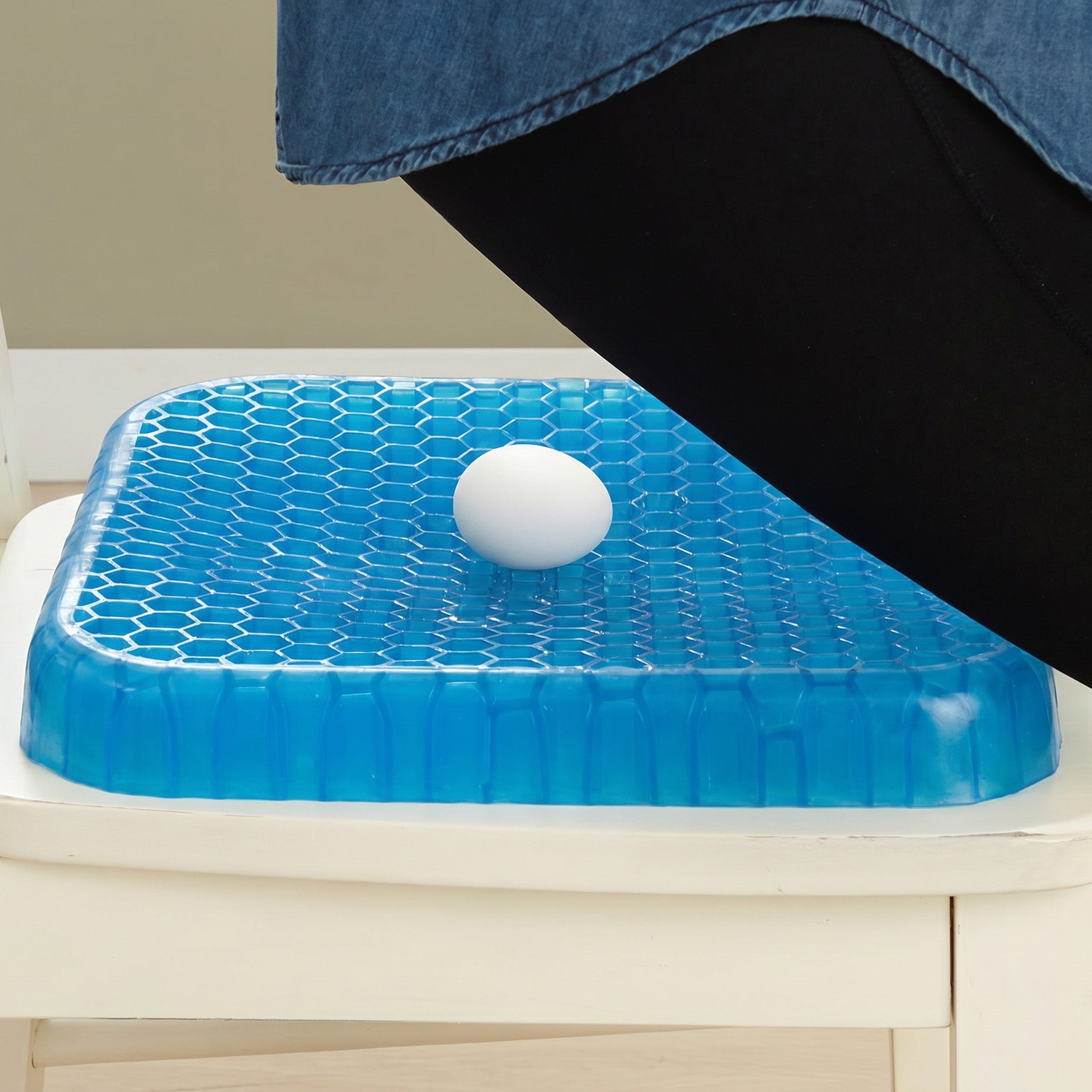 Blue gel seat cushion with an egg on top, placed on a chair.